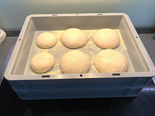 Pizzaballenbox mit Teigballen - Das Bild zeigt zwei Pizzaballenboxen, die übereinander gestapelt sind. Die obere Box ist offen und es sind 4 grosse und 2 kleine Teigballen darin zu sehen.